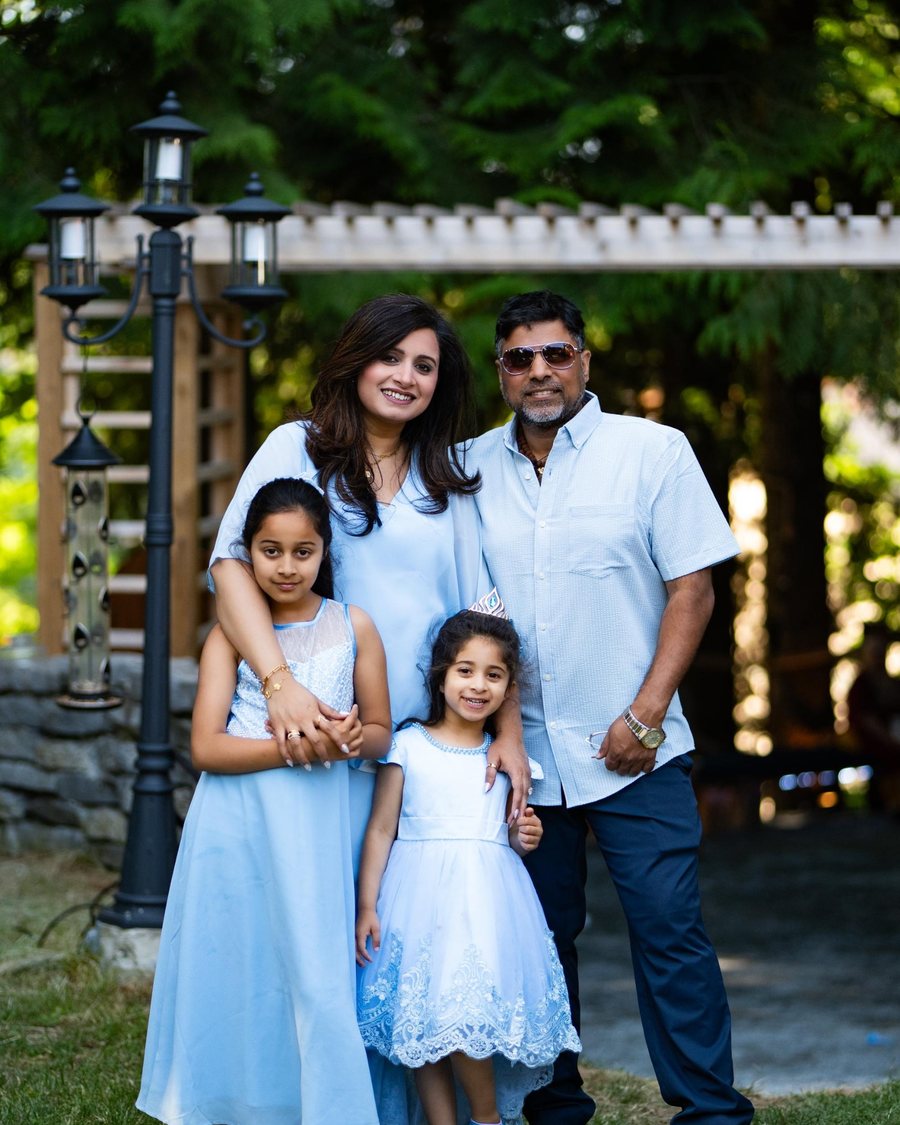 Virender with his wife and two daughters outdoors